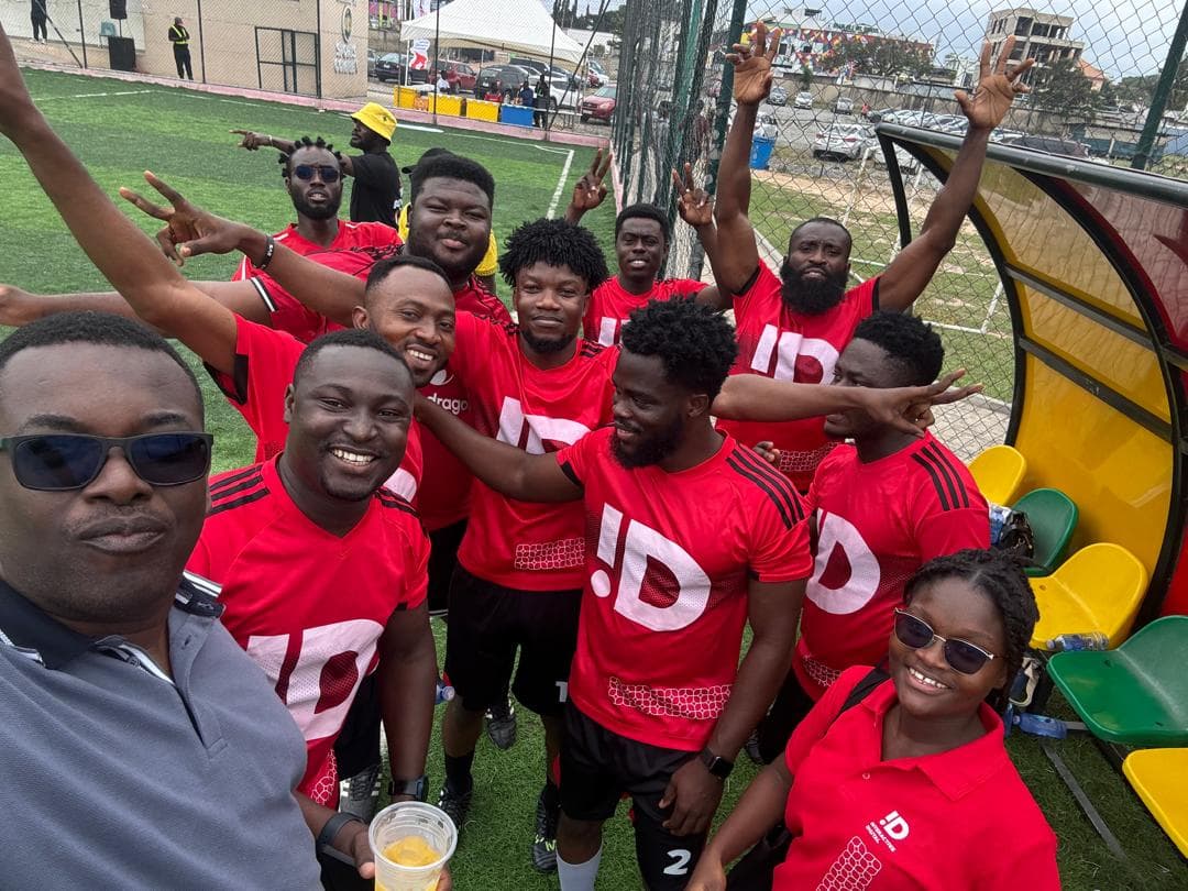 The Interactive Digital football team in red jerseys, arms raised